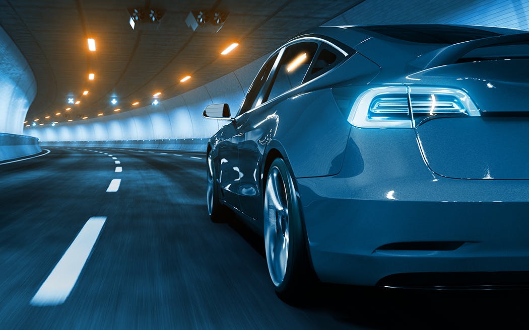 Modern Electric car rides through tunnel with warm yellow light 3d rendering 1050x656